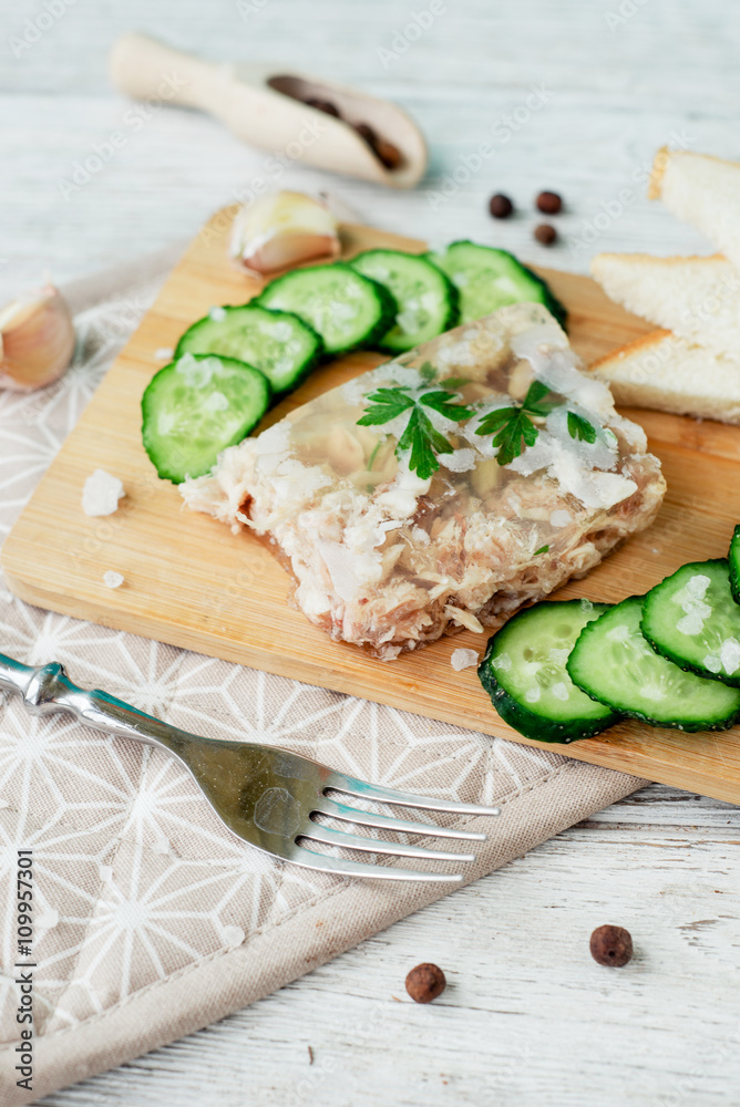 Ukrainian and Russian national cuisine , the dish is called brawn , boiled pork and turkey in jelly of bouillon with fresh cucumber , salt and spices on a wooden background
Ukrainian and Russian national cuisine , the dish is called brawn , boiled pork and turkey in jelly of bouillon with fresh cucumber , salt and spices on a wooden background