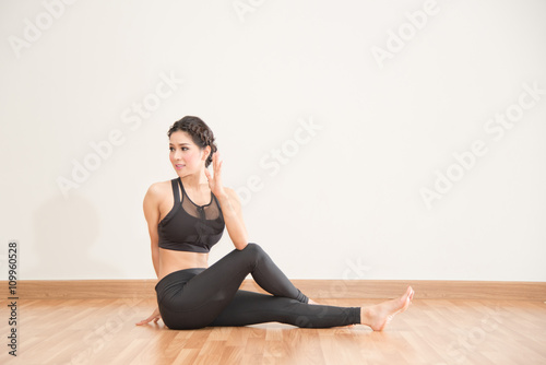 young woman practicing yoga on wooden floor