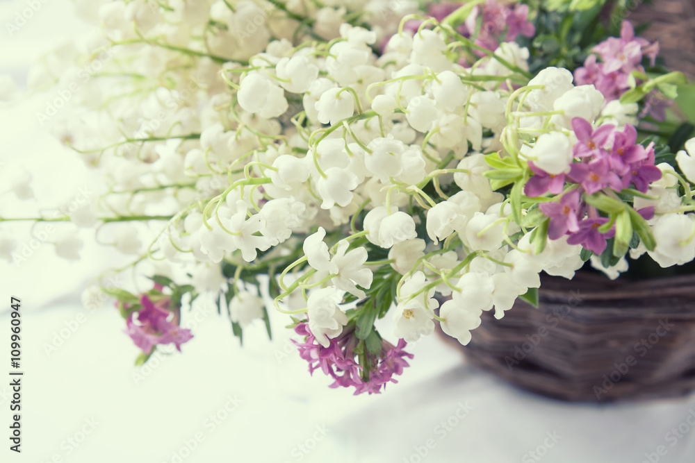 White lily of the valley on a light wooden table