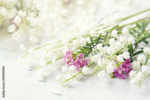 Fototapeta Naklejka Na Ścianę i Meble -  White lily of the valley on a light wooden table