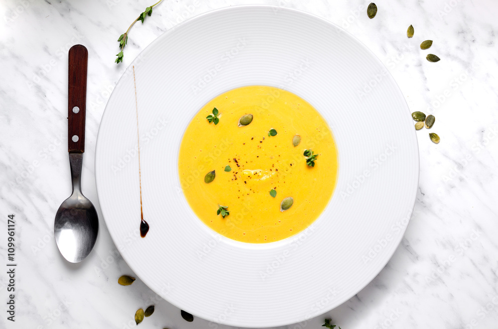 Naklejka Pumpkin soup in a bowl with spoon on a murble
