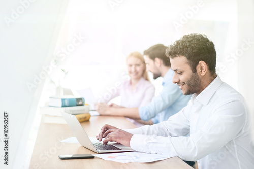 Cheerful male student is working on computer