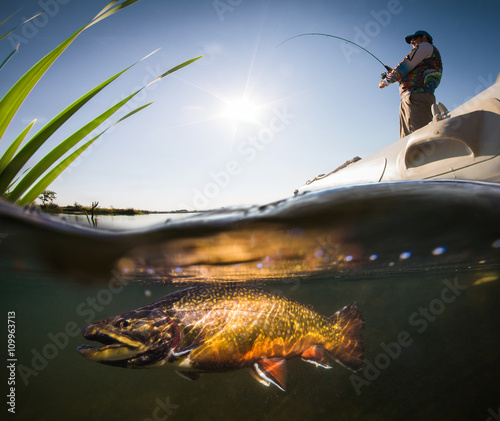Fisherman with rod in the boat and underwater view