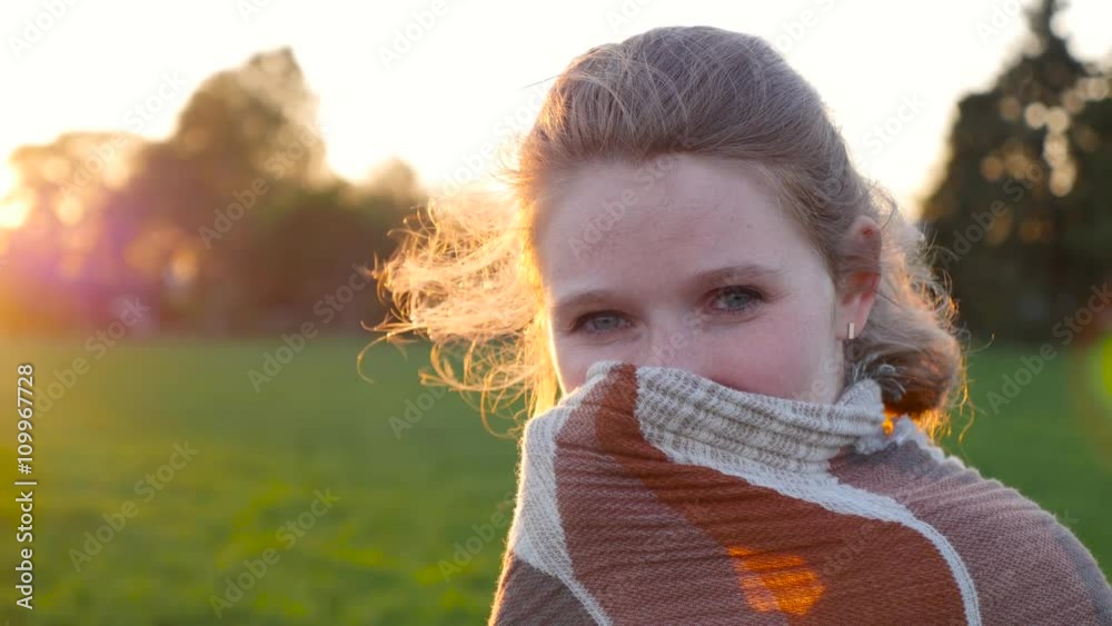 shy girl hidden behind a scarf in the sunshine