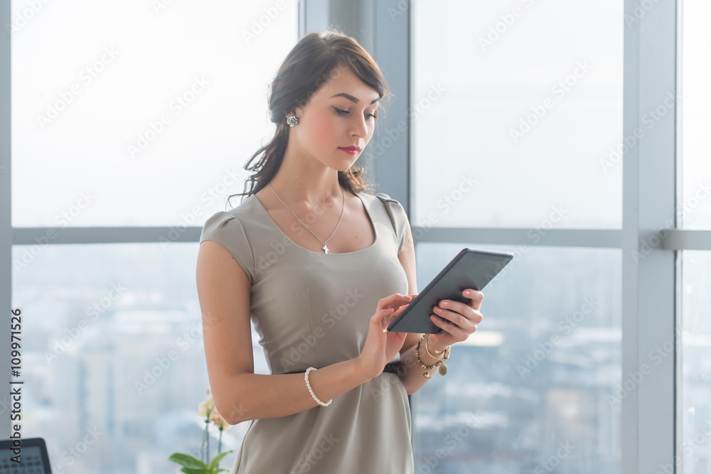 Close-up portrait of a young attractive freelancer using tablet for telework, typing and reading new messages on-line. Close-up portrait of a young attractive freelancer using tablet for telework, typing and reading new messages on-line.