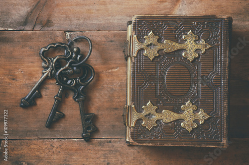 top view of antique book cover and old keys