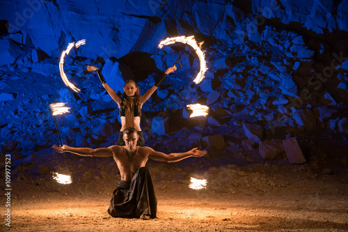 Photography Fireshow performance in the desert near the rock illuminated with blue