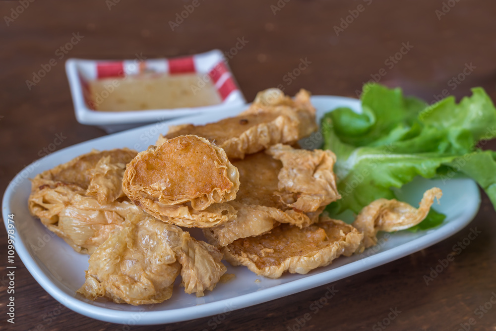 Deep fried crab meat rolls served on white plate on wooden table Deep fried crab meat rolls served on white plate on wooden table