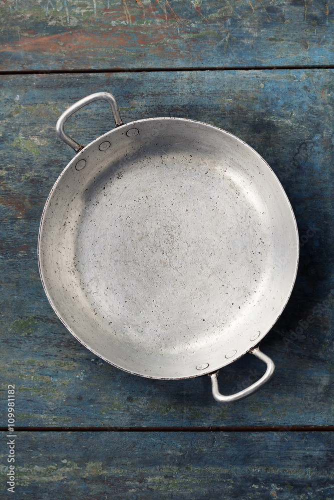 old empty cooking pot on rustic wooden background, top view com old empty cooking pot on rustic wooden background, top view com