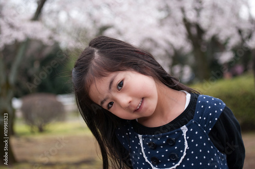 桜の咲く公園で微笑む日本人の女の子