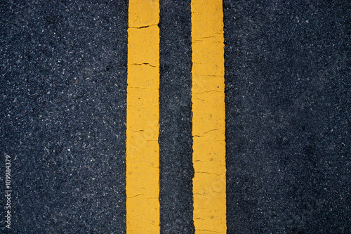 Two yellow traffic lines. on thr road. © noppharat