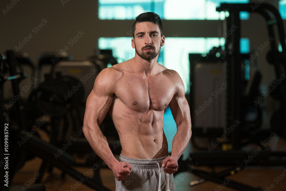 Muscular Man Flexing Muscles In Gym Muscular Man Flexing Muscles In Gym