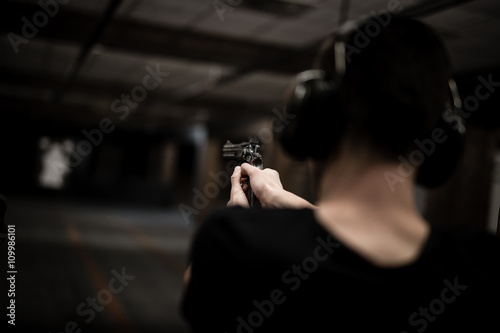 Man aiming revolver at target in indoor firing range or shooting range