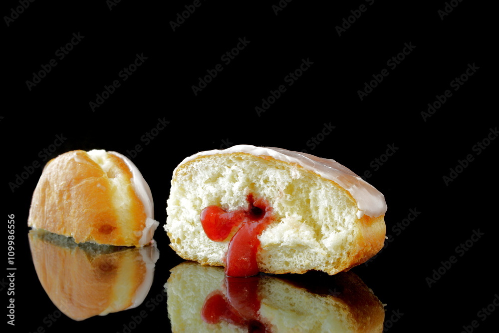 ein halbierter berliner pfannkuchen auf schwarz ein halbierter berliner pfannkuchen auf schwarz