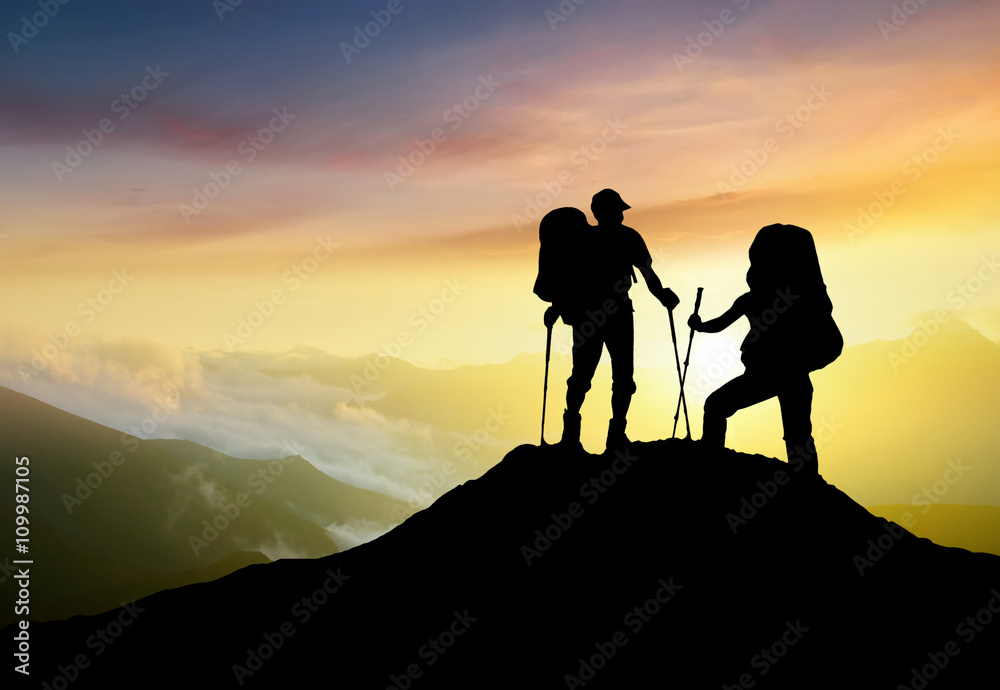 Silhouettes of team on mountain peak. Sport and active life concept..