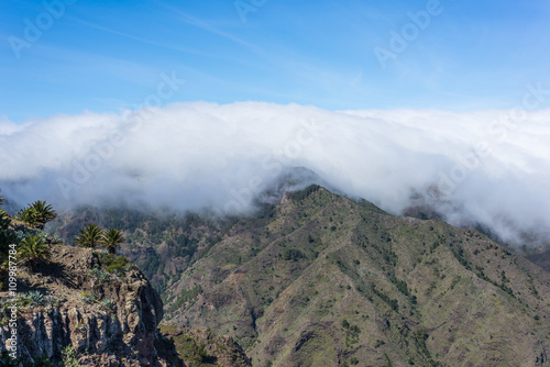 Huge clouds and trade winds from subtropical climate comes from the Azores and reaches La Gomera in approx. 800m altitude. Overlook from the Mirador de La Laja to the canyon Barranco de la Laja
