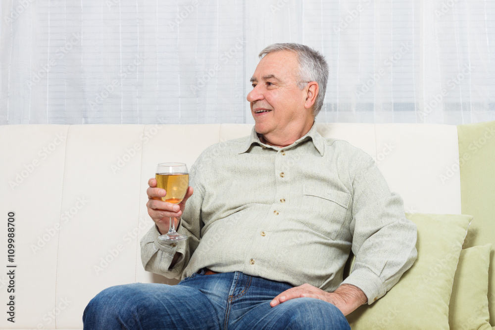 Senior man enjoys drinking wine at home. Senior man enjoys drinking wine at home.