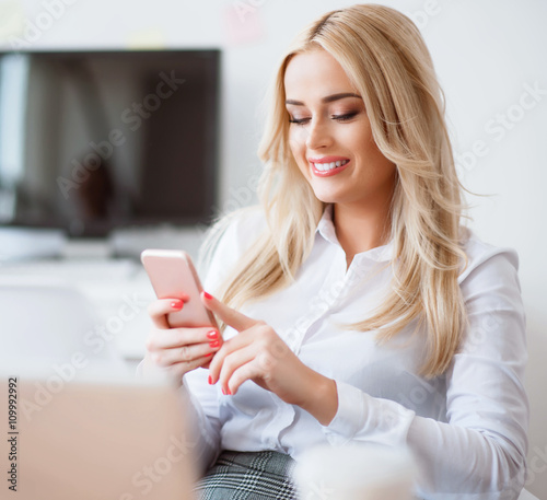 Positive beautiful business woman  using smart phone 