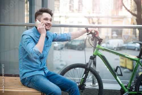 Cheerful guy talking on cell phone 