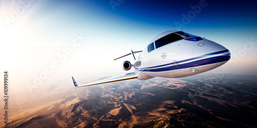 Realistic photo of white generic design private Jet flying over the mountains. Empty blue sky with sun at background.Business Travel by modern Luxury Plane.Horizontal.Closeup image. 3d rendering