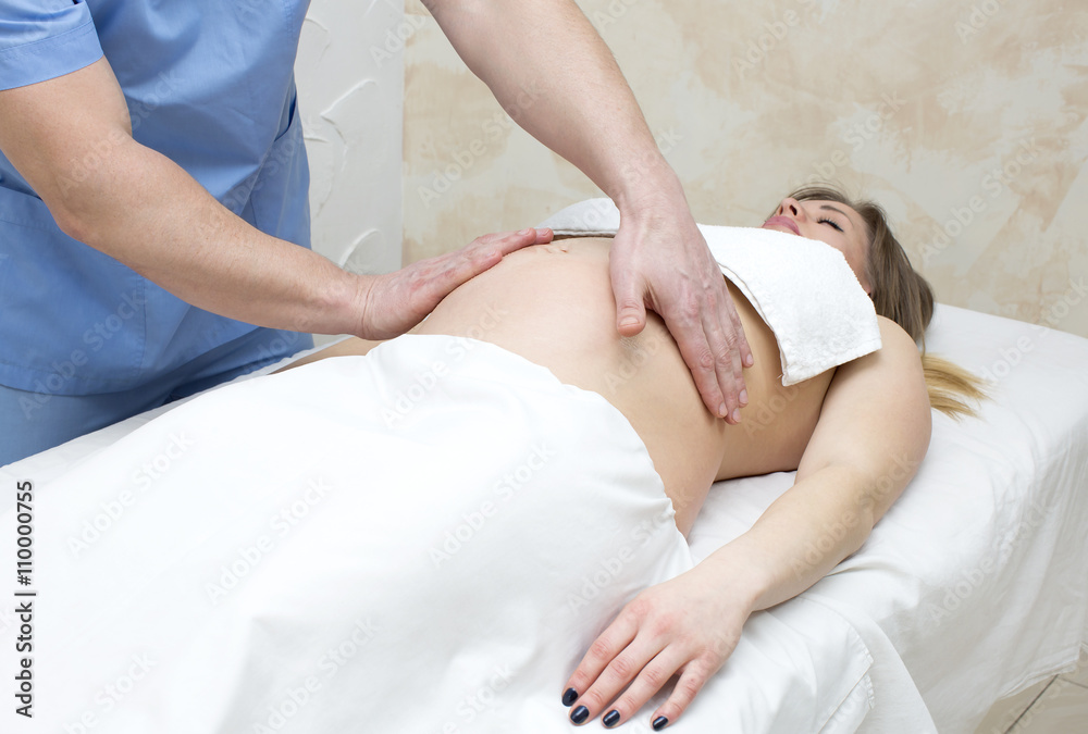 Fototapeta premium processes salon doing massage to a pregnant woman