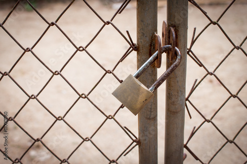 old lock and a rusty chain on an iron gate