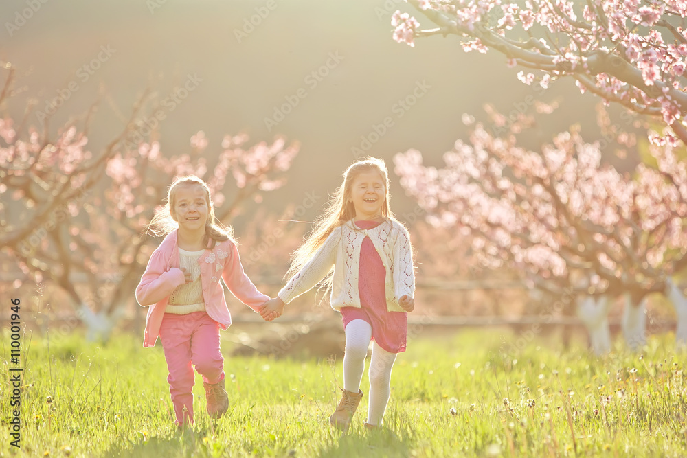 Fototapeta premium Kids are playing in a spring tree garden