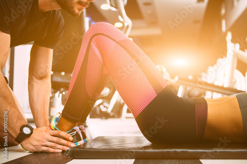 Fit woman working out with trainer at the gym