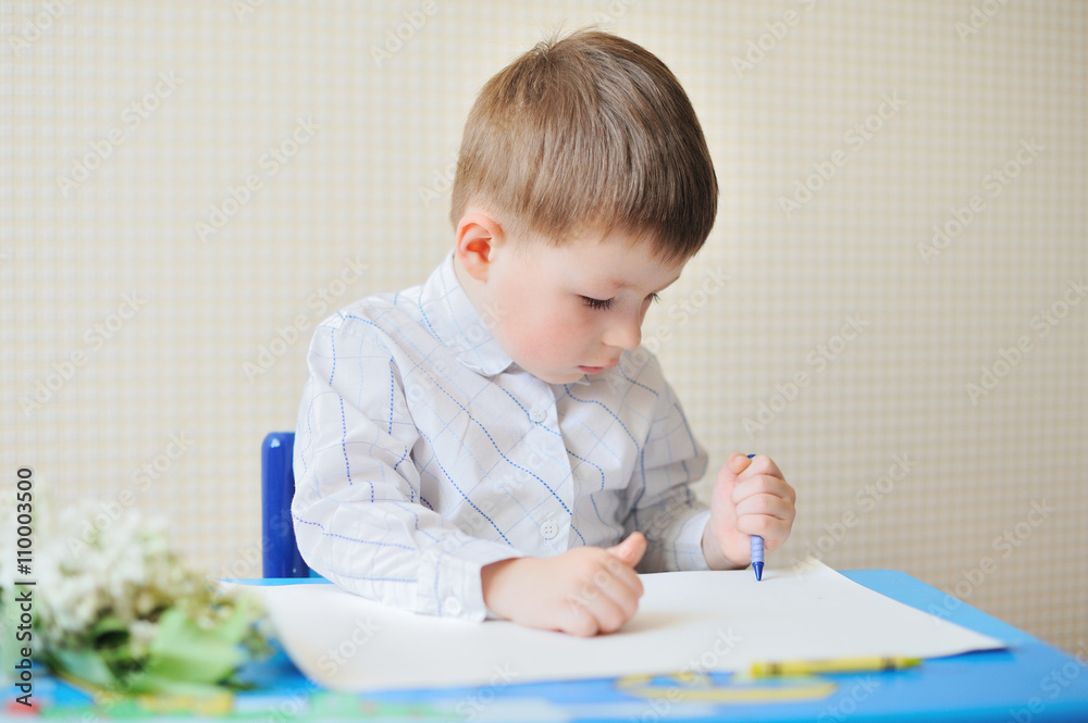 Portrait of cute boy with pen and paper at desk in classroom Portrait of cute boy with pen and paper at desk in classroom