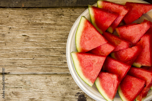 Seedless watermelon cut into wedges on wood background