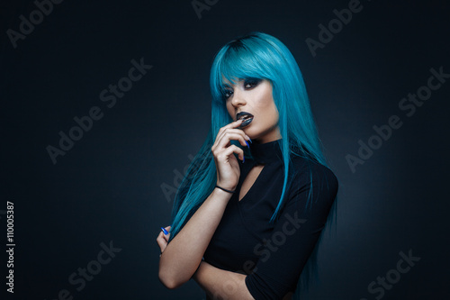 Portrait of a young woman with a cyan color hair