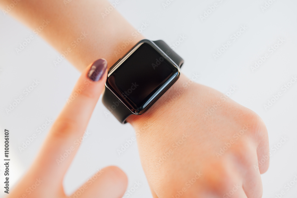 Close up female touching screen of smart wrist watch Close up female touching screen of smart wrist watch