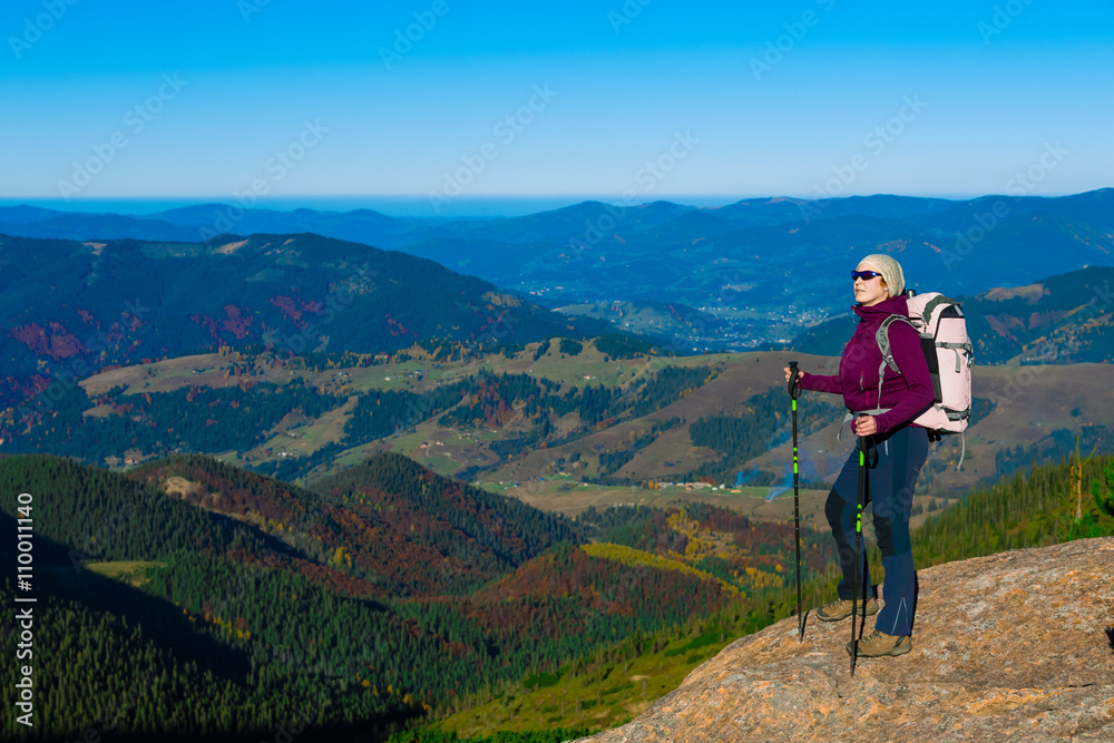 Hiker Staying on High Rock and Mountain View with Autumnal Forest
