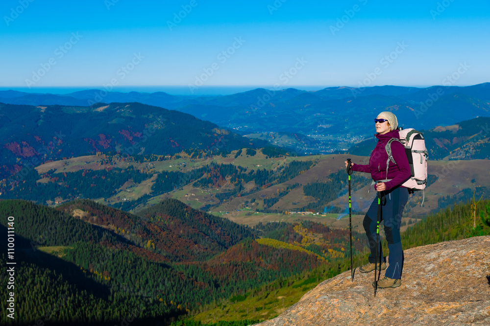 Hiker Staying on High Rock and Mountain View with Autumnal Forest Hiker Staying on High Rock and Mountain View with Autumnal Forest