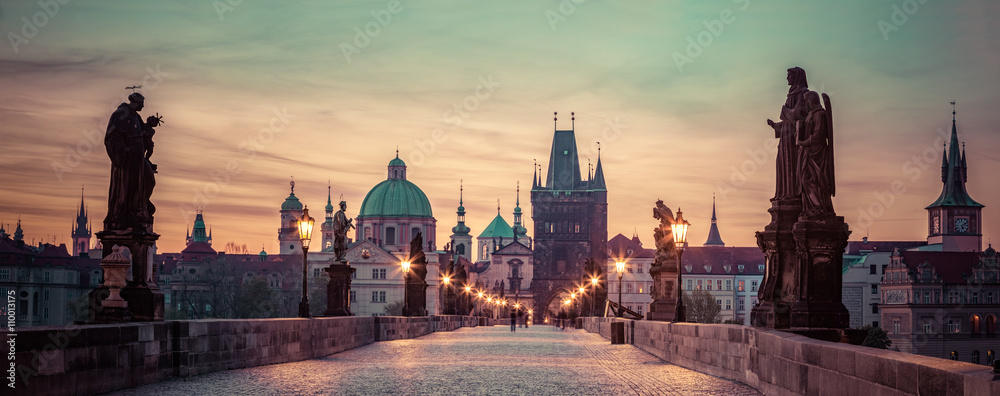 Naklejka premium Most Karola o wschodzie słońca, Praga, Republika Czeska. Dramatyczne posągi i średniowieczne wieże.