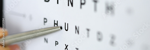 Silver ballpoint pen pointing to letter in eyesight check table photo