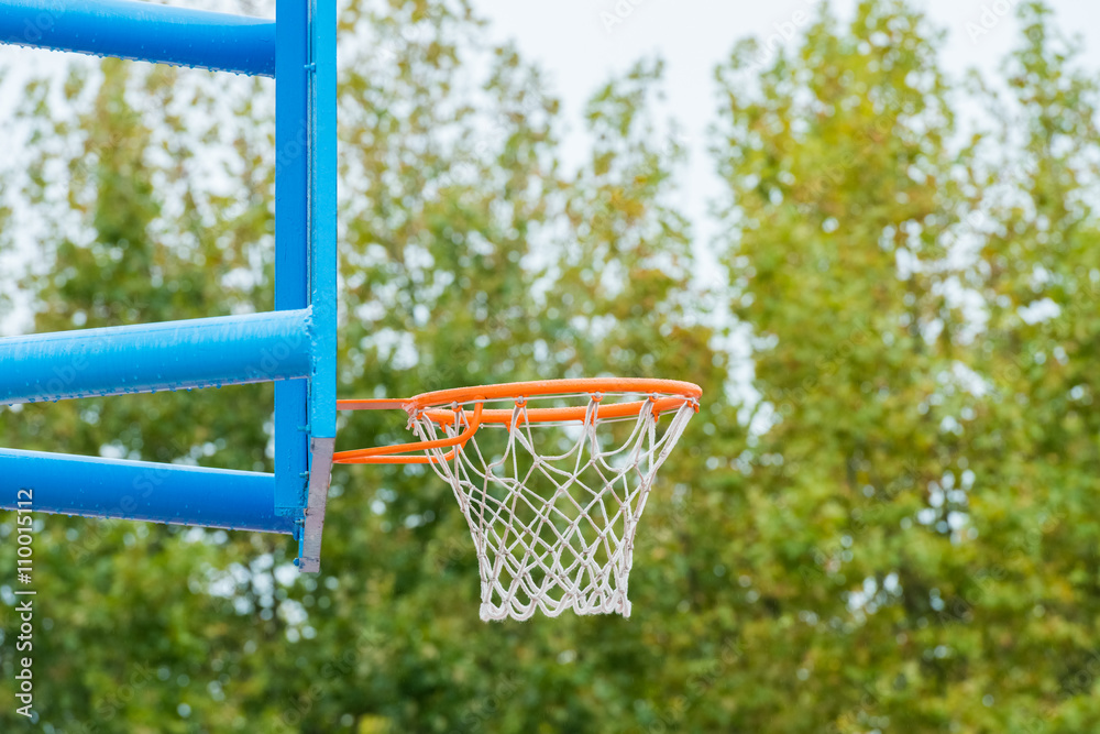 basketball backboard with a ring on a street court