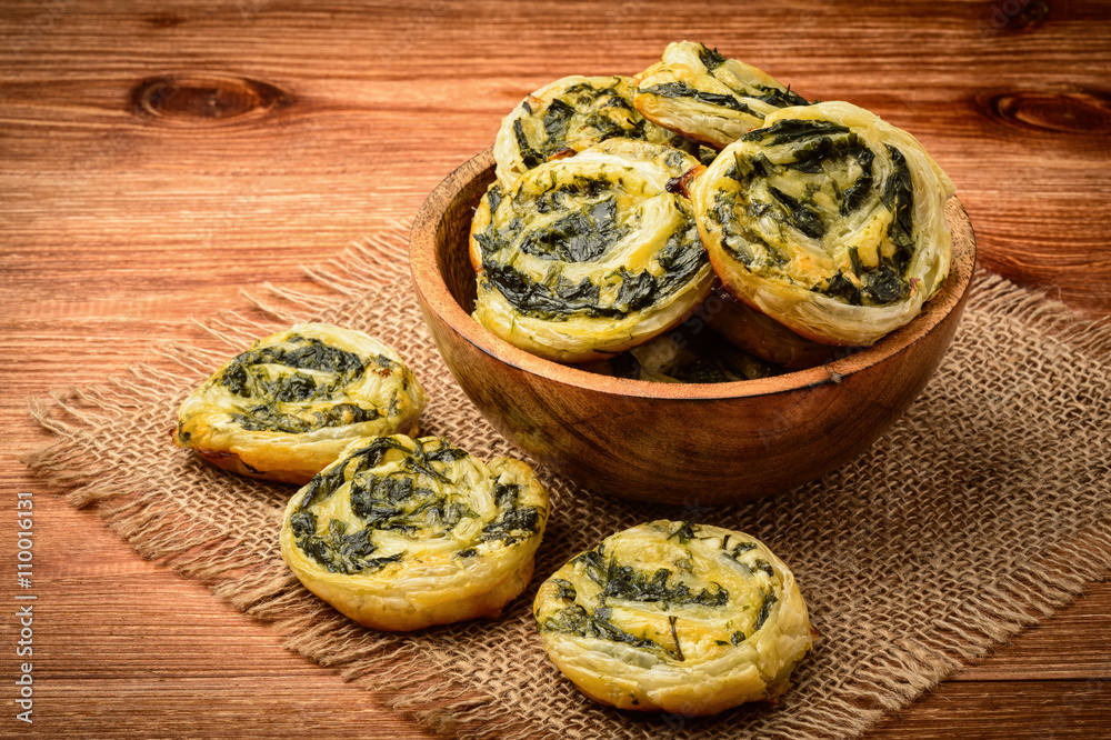 Fototapeta premium Spinach and feta puffs on wooden background.