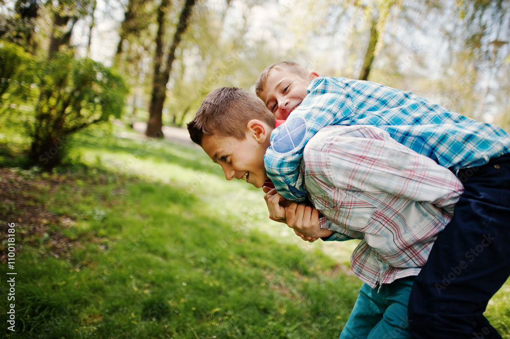 Two brother boy with headphones having fun on park. Brother love