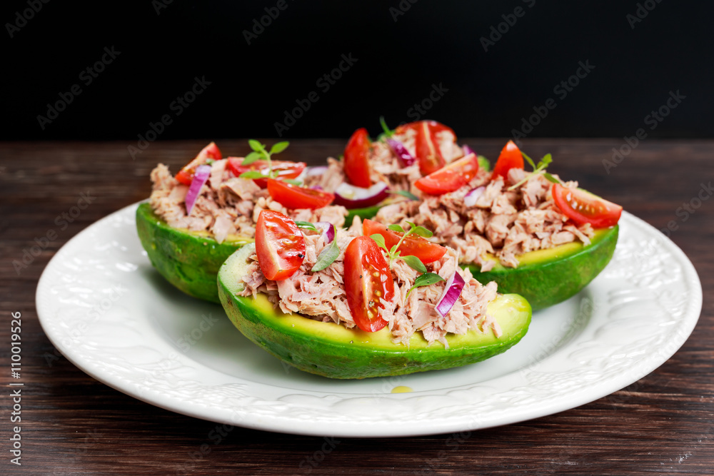 Avocado boats stuffed with tuna, red onion and cherry tomatoes. Avocado boats stuffed with tuna, red onion and cherry tomatoes.