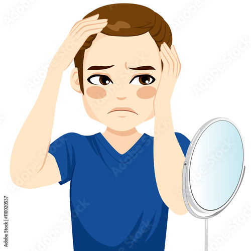 Male looking in a mirror worried about hair loss