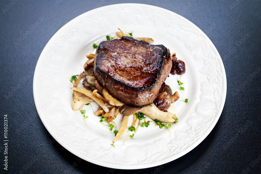 Tasty Beef Mignon steak with mushrooms and herbs on plate Tasty Beef Mignon steak with mushrooms and herbs on plate