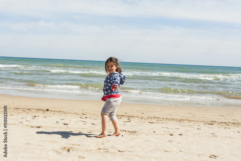 Rear view full shot girl walking to the shore of the beach in a