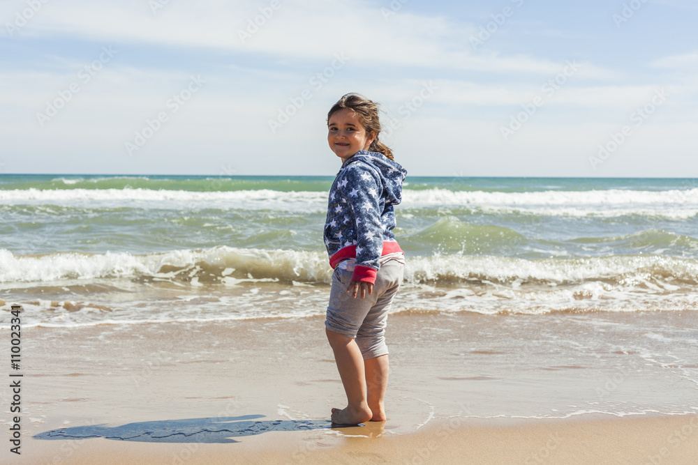 Rear view full shot girl walking to the shore of the beach in a