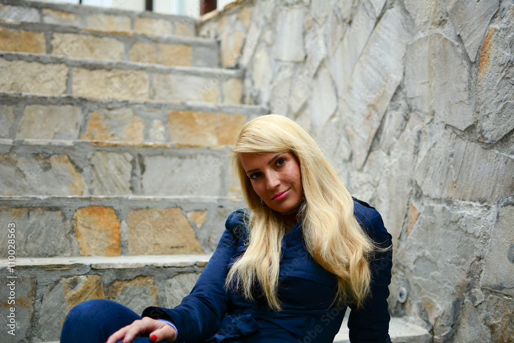 Beautiful Young sexy attractive girl with blond hair on a concrete stairs