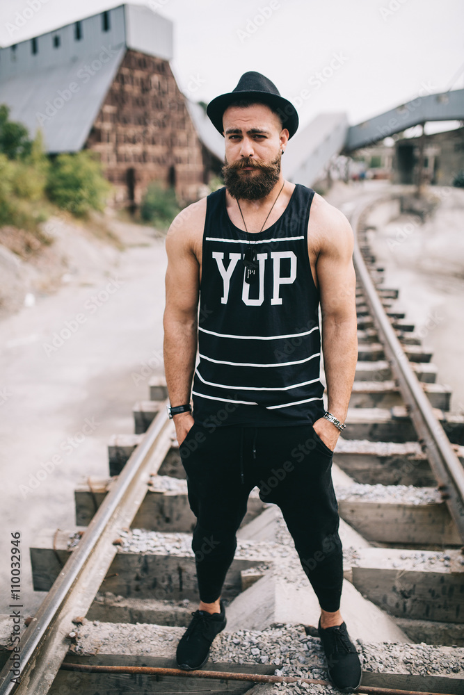 Stylish and fashionable bearded man posing on a outdoor