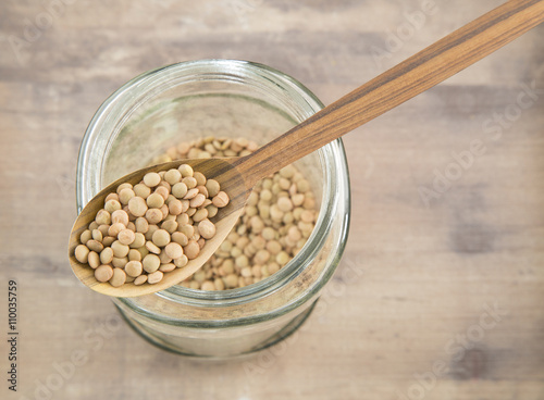 Lentils in glass bowl and wooden spoon