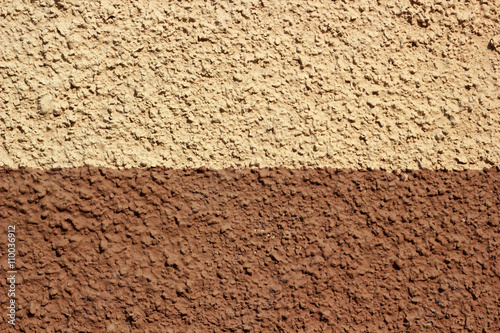 фотографія Half colored plaster texture wall. Exterior brown and beige stuc