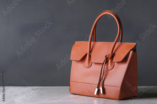 women leather handbag on gray background photo