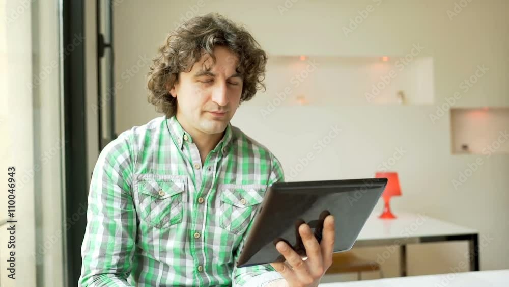 Man browsing internet on tablet and looking to the camera, steadycam shot
Man browsing internet on tablet and looking to the camera, steadycam shot